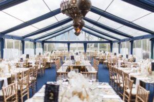 a room with tables and chairs under a clear tent