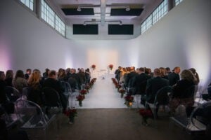 a group of people sitting in chairs in a room with a man standing in front of them