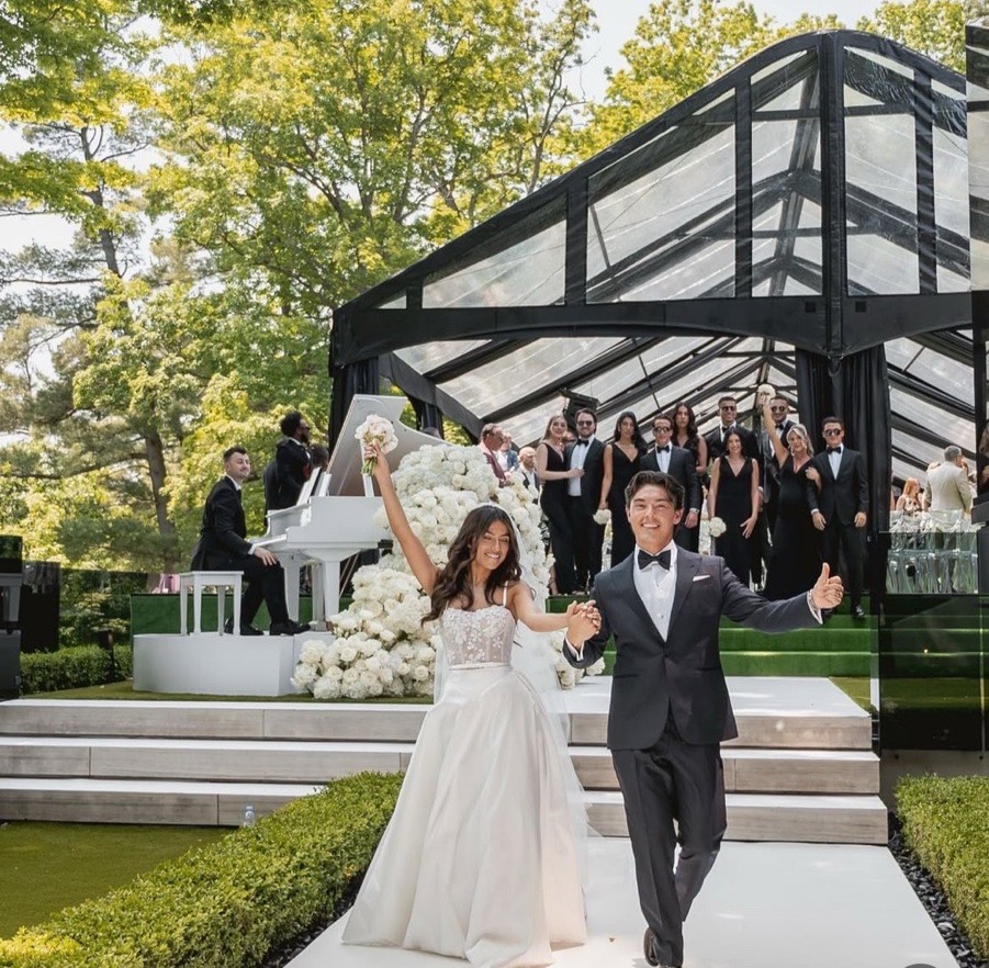 Wedding couple celebrating under Black Framed Clearspan Tent Rental