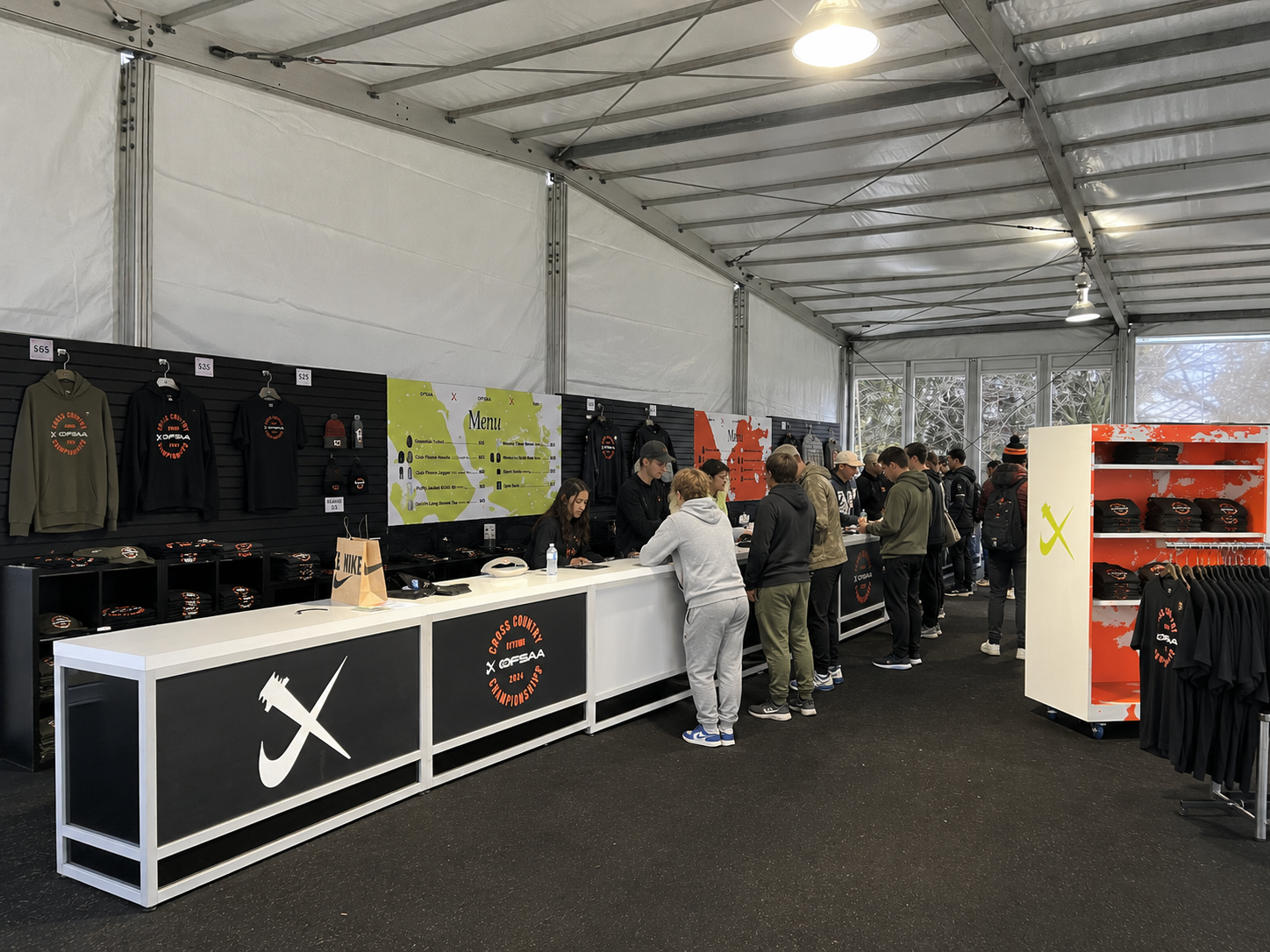 Merchandise tent with customers shopping.