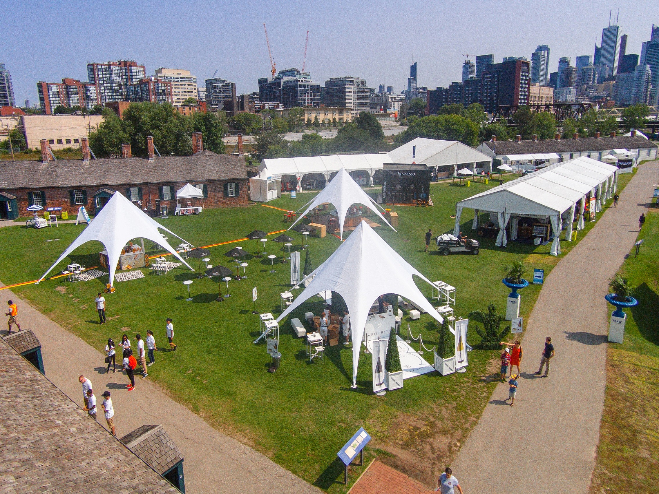 Outdoor event with tents and people.