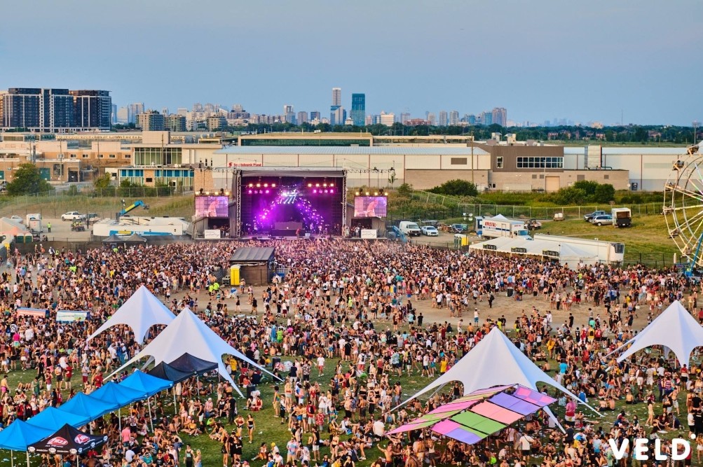 Crowd at outdoor music festival with star shade tent