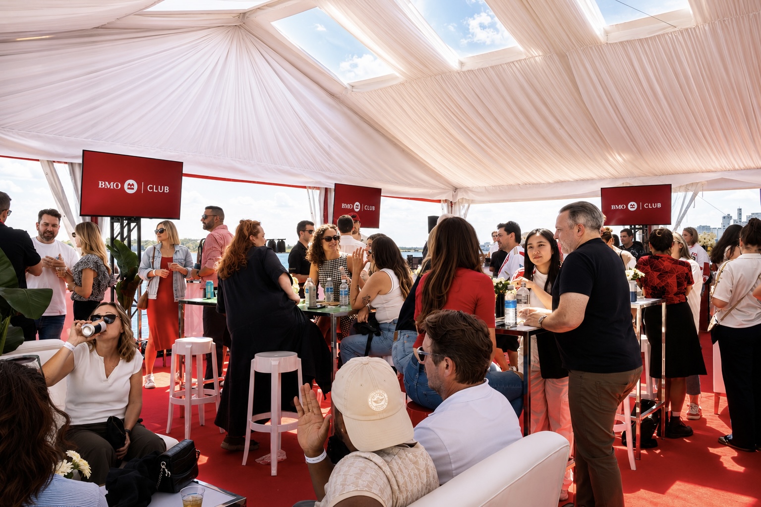 People socializing under a tent.